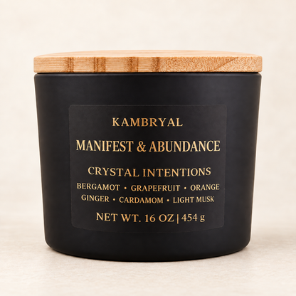 KAMBRYAL Manifest & Abundance 16 oz three wick candle in a matte black vessel with bamboo lid